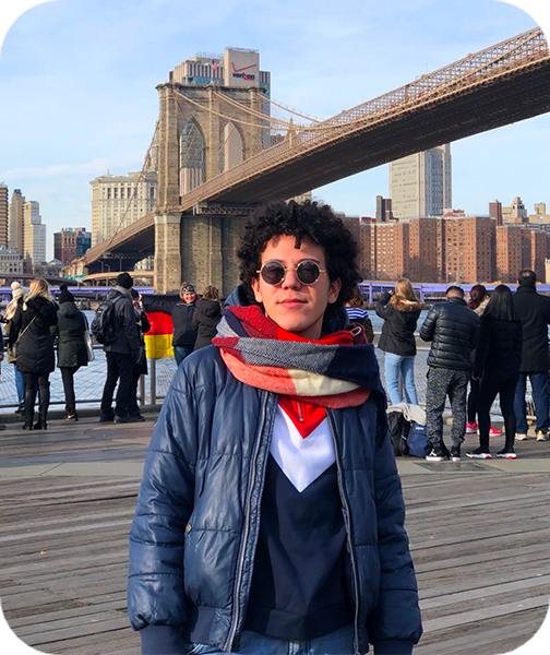 Ragazzo, partito con il Select Program One-term per gli Stati Uniti, in posa davanti il Brooklyn Bridge di New York